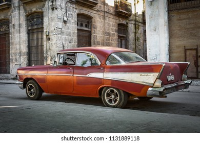 Havana/Cuba - December 24, 2017: Red And White American Made Car Drives Through An Old Town In Havana