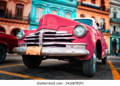 HAVANA,CUBA - JUNE 5,2019 : Old car painted hot pink and colorful buildings in Havana Redaktionelt stock-foto