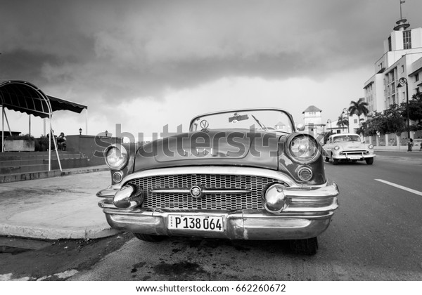 HAVANA,CUBA-OCTOBER 14:People and old car on\
streets of Havana October 14,2015 in Havana. With 2.4 mil.\
inhabitants in the city and 3.7 in its urban area, Havana is the\
largest city in the\
Caribbean