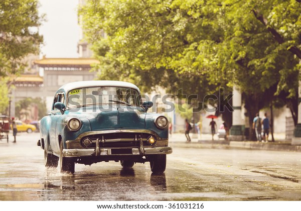 HAVANA,CUBA-OCTOBER 15:People and old car on\
streets of Havana October 15,2015 in Havana. With 2.4 mil.\
inhabitants in the city and 3.7 in its urban area, Havana is the\
largest city in the\
Caribbean