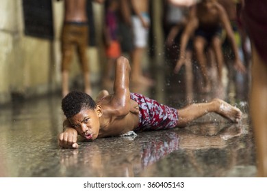 HAVANA-OCTOBER 15:Children playing on streets of Havana on rain in October 15,2015 in Havana.With 2.4 mil. inhabitants in the city and 3.7 in its urban area,Havana is the largest city in the Caribbean - Shutterstock ID 360405143