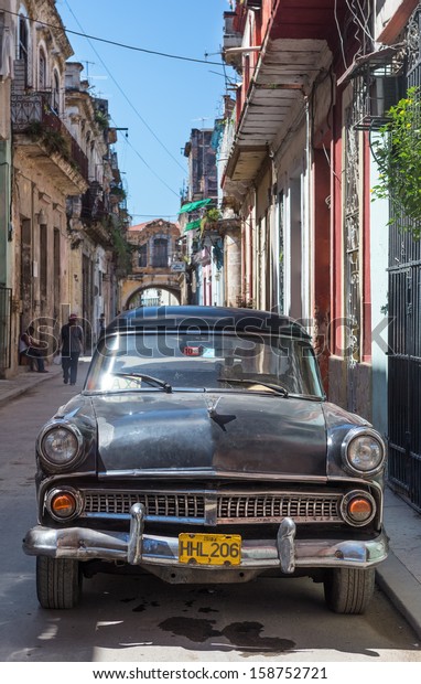 HAVANA-OCTOBER 17:Old american car in a street\
sidelined with decaying buildings October 17,2013 in Havana.These\
cars,still in use after many decades,have become a worldwide known\
symbol of Havana