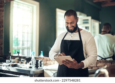 I have clients from all over the world. a handsome young barber standing alone and using a digital tablet in his salon. - Powered by Shutterstock