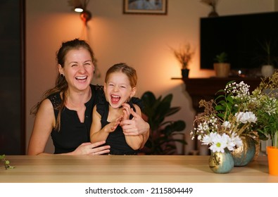 Have Fun Halloween. Two Girls And Pumpkin On Table. Bright Background With Orange Illumination. Joy Of Holiday. Hug And Laugh Sisters. Mom With Daughter Are Happy At Home. Woman In Black. Flower Vase