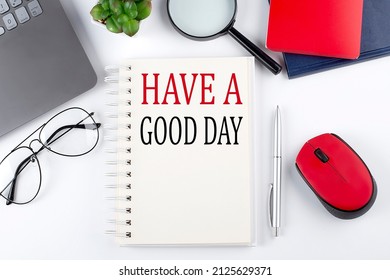 HAVE A GOOD DAY text on notepad with laptop on the white background