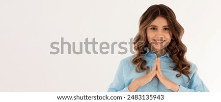 I have great evil plan. Good-looking confident and tricky woman in blue shirt, holding fingers together and smirking at camera, having some bad intention in mind, planning to commit crime