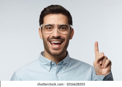 I have an idea! Handsome business man keeping finger pointed upwards, showing something above his head, making gesture with index finger. Eureka, solution sign concept - Powered by Shutterstock