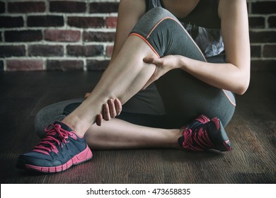 Have A Leg Cramp In Fitness Exercise Training, Healthy Lifestyle Concept, Indoors Gym Wooden Floor Brick Wall Background