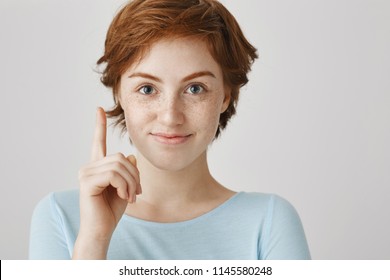 I have my point of view you need to listen. Attractive pleasant european woman with red hair and freckles showing index finger as if having idea, wanting to say it or mention something during talk - Shutterstock ID 1145580248