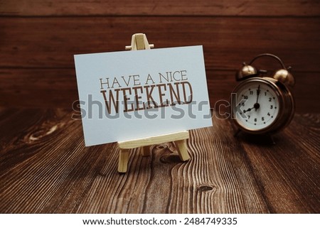 Have a nice weekend text on paper card on wooden background