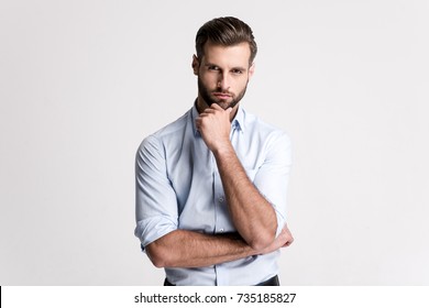 
I have some doubt. Handsome young man looking at camera and keeping hand on chin while standing against white background.
 - Shutterstock ID 735185827