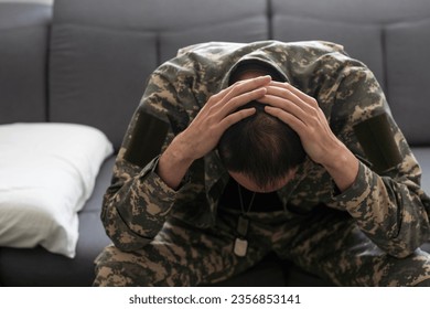 Having flashbacks. Post traumatic stress disorder. Soldier in uniform sitting indoors.