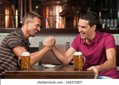 Having fun at the bar. Two friends drinking beer and having fun at the pub - Powered by Shutterstock