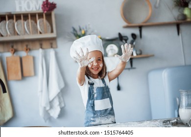 Having Fun. Cute Kid In White Chef Uniform Preparing Food On The Kitchen.