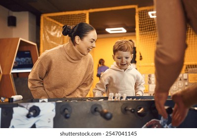 Having fun. Family of dad, mother and son that are playing table football game indoors. - Powered by Shutterstock