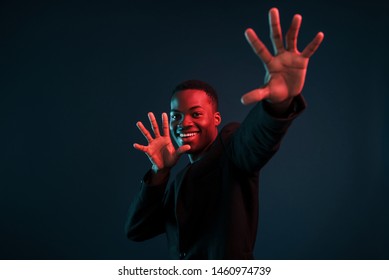 Having Fun. Futuristic Neon Lighting. Young African American Man In The Studio.