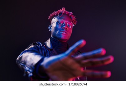 Having Fun. Futuristic Neon Lighting. Young African American Man In The Studio.