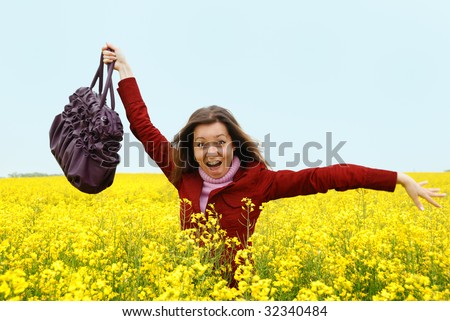 The having fun girl in the field of yellow flowers