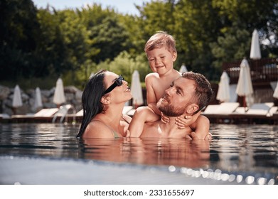 Having fun. Happy family of father, mother and son are in the pool. - Powered by Shutterstock