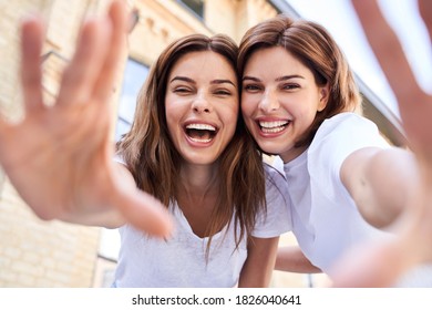 Having fun. Happy girl keeping smile on their faces while spending time together. Woman reach out to the camera - Powered by Shutterstock