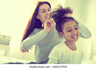 Having fun. Mom and daughter hanging out together trying out hairstyles. - Powered by Shutterstock