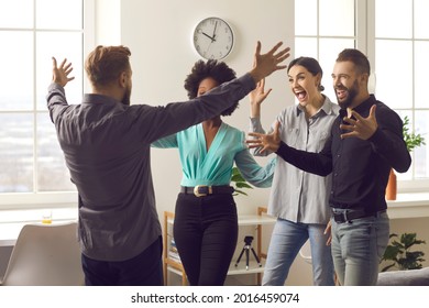 Having Fun Reunion. I'm Back. Long Time No See. Happy Man Spreading Arms Wide Open To Hug Friends He Missed So Much. Group Of Funny Men And Women Excited To Meet Coworker Who Returned From Far Away