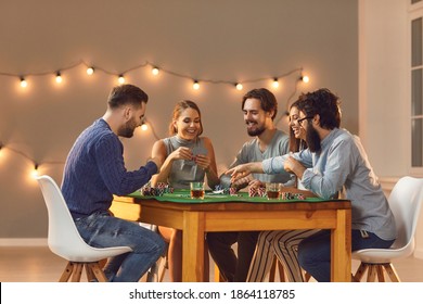 Having fun together at casino themed party. Group of happy, smiling, young friends enjoying start of weekend, having drinks, sitting at table and playing game of poker - Powered by Shutterstock