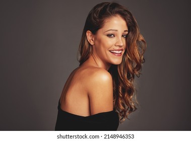 Having A Good Hair Day. Studio Shot Of A Beautiful Woman With Long Locks Posing Against A Grey Background.