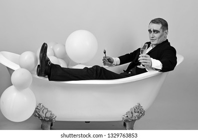 Having a good time. Comedian actor celebrate holidays. Mime actor enjoy bathing in bath tub. Mime man has celebration party with food and drink. Happy bubble bath day. Bathing and relaxing.