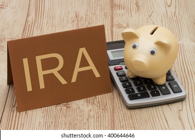 Having A IRA Plan, A Golden Piggy Bank, Card And Calculator On Wood Background With Text IRA