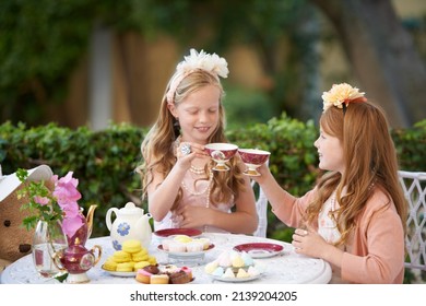 Having a make-believe tea party. Two young girls having a tea party in the backyard. - Powered by Shutterstock