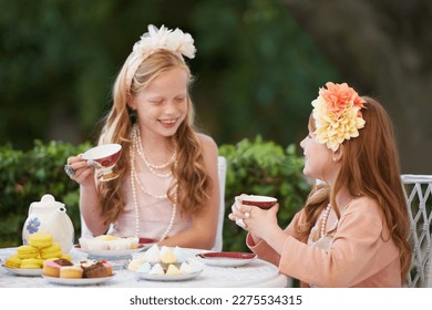 Having a make-believe tea party. Two young girls having a tea party in the backyard. - Powered by Shutterstock