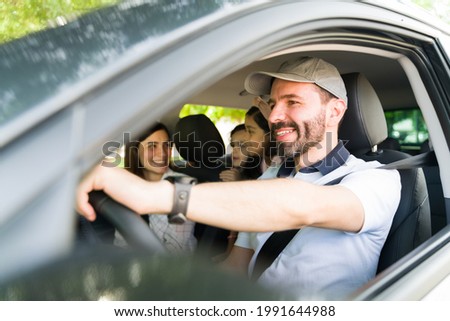Having so much fun during the road trip. Young parents driving their kids to the beach. Mom and dad laughing and joking with their kids while traveling by car 
