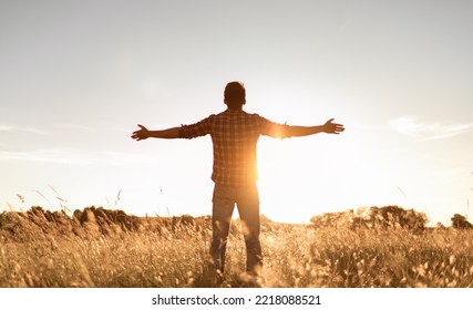 Having a positive mindset, wellbeing and hope concept. Happy young man standing in a nature sunrise field with arms outstretched.	 - Shutterstock ID 2218088521