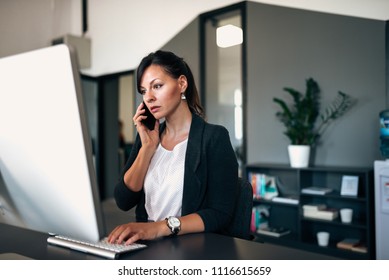 Having Serious Phone Conversation With Colleague While Solving Problem On The Computer.