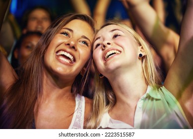 Having the time of their lives. Young girls in an audience enjoying their favourite bands performance.