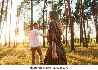 Having A Walk. Happy Couple Is Outdoors In The Forest At Daytime.