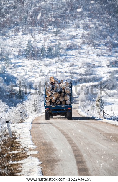 Havy\
load truck transporting logs on the winter\
raoad