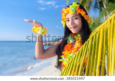 Hawaii hula dancers on the tropical sea beach invitation to an exotic tropical vacation  with a palm leaf shows blue sky. 