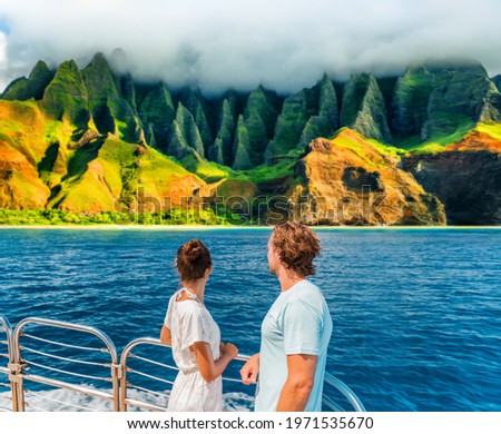 Hawaii Kauai Na Pali coast landscape scenic cruise. Couple watching dramatic mountains famous tourist destination on boat deck. Cruise ship on summer travel vacation and woman tourists relaxing.