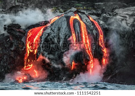 Hawaii lava flow entering the ocean on Big Island from Kilauea volcano. Volcanic eruption fissure view from water. Red molten lava.