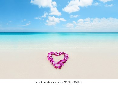 Hawaii Love Honeymoon. Heart Shape Lei Flowers On Perfect White Sand Beach For Hawaii Honeymoon Romantic Vacation Getaway Travel. Pink Orchids Flower Necklace Lying On Paradise Background.