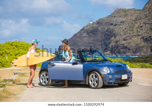 Hawaii surfers\
people lifestyle happy living friends talking on beach relaxing\
from surfing with surfboards. Friends laughing having fun in Oahu\
island, USA travel\
lifestyle.
