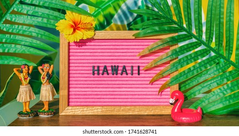 Hawaii Travel Retro Sign With Hula Dancing Dolls Pink Flamingo Toy Float And Plastic Palm Tree Leaves For Kitsch Board. Hawaiian Vacation Summer Holidays Background.