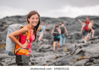 Hawaii Volcano Hike Adventure Happy Asian Woman With Backpack In Big Island, Hawaii. Hiking Group Of Tourists Walking On Black Lava Field Trail. Smiling Asian Girl Outdoor USA Summer Travel Vacation.