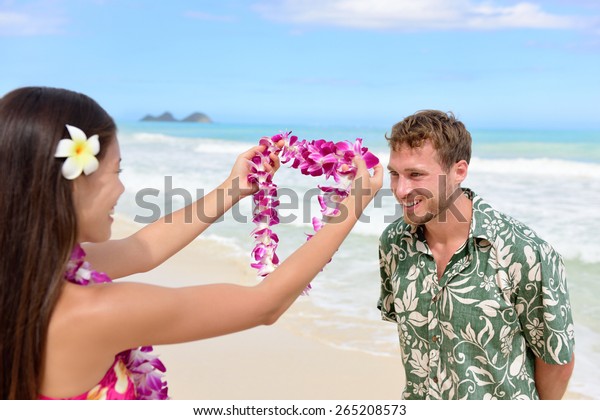 ハワイの海岸で観光客を歓迎するピンクのランの花輪を与えるハワイの女性 お客様に花のネックレスを贈るというポリネシアの文化の伝統を 歓迎の身振りで描いたもの の写真素材 今すぐ編集