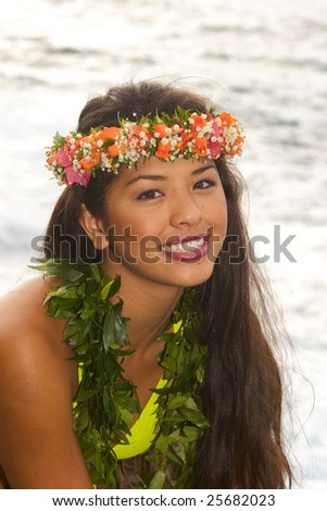 hawaiian girl in a bikini with flowers on lava cliffs by the ocean in Hawaii