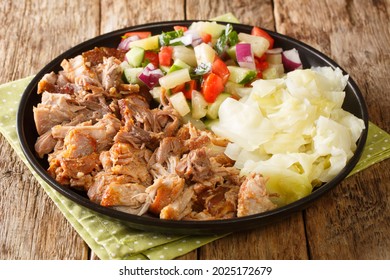 Hawaiianisches Kalua-Schweinefleisch mit gedünstetem Kohl und frischem Salat, Nahaufnahme in einem Teller auf dem Tisch. horizontal