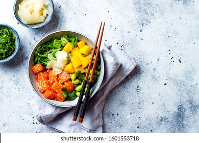 Hawaiian Salmon Poke Bowl With Seaweed, Avocado, Edamame, Mango And Pickled Ginger. Top View, Overhead, Flat Lay