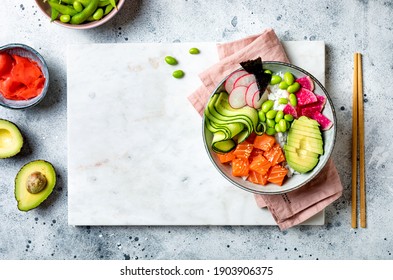 Hawaiian Salmon Poke Bowl With Seaweed, Avocado, Watermelon Radish, Edamame And Cucumber. Top View, Overhead